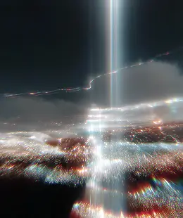 City lights at night with vertical beams of bright light piercing the sky and atmospheric haze.