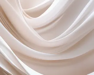 Close-up of smooth, flowing white fabric with soft folds and shadows.